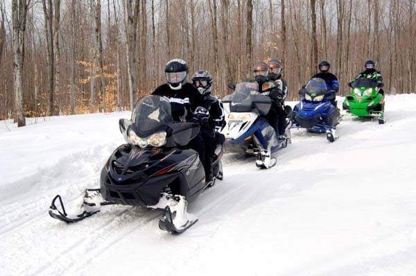 people riding snow mobile in snow