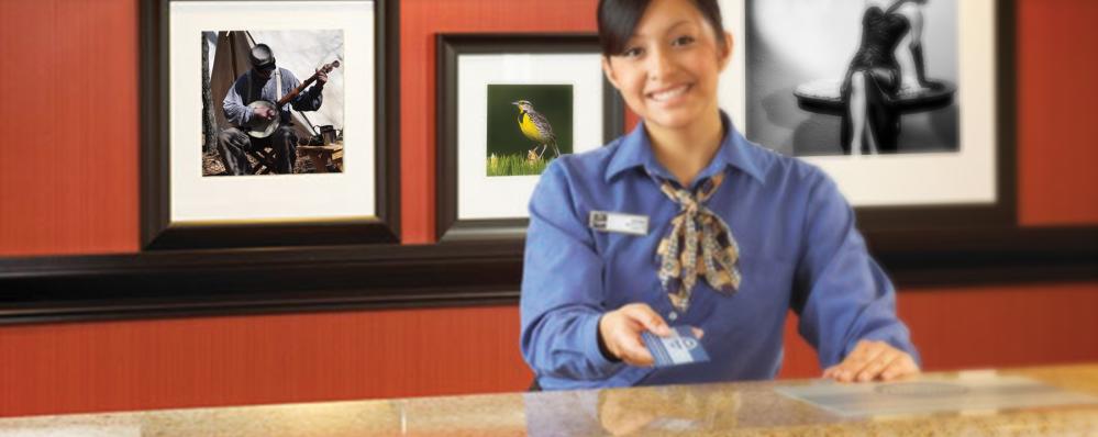A hotel worker holding a hotel key card at a hotel in Johnston County, NC.