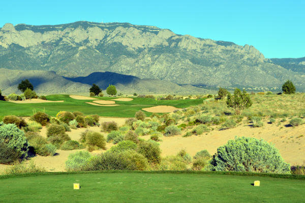 An image of a golf course with the Sandia Mountains in the background