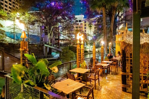 Tiki torches lit on restaurant patio Hugmans Oasis