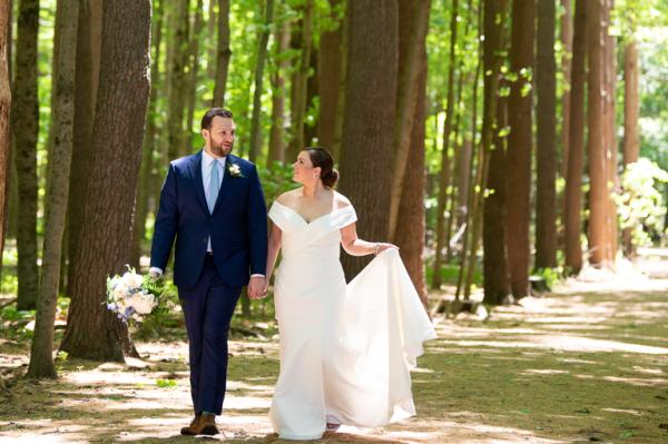 bride and groom walking in the woods