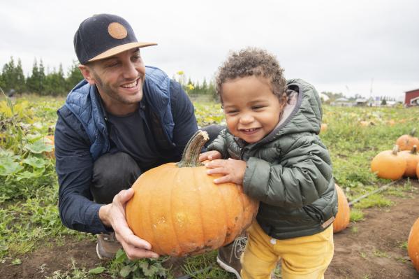Father and son picking pumpkins at the pumpkin patch