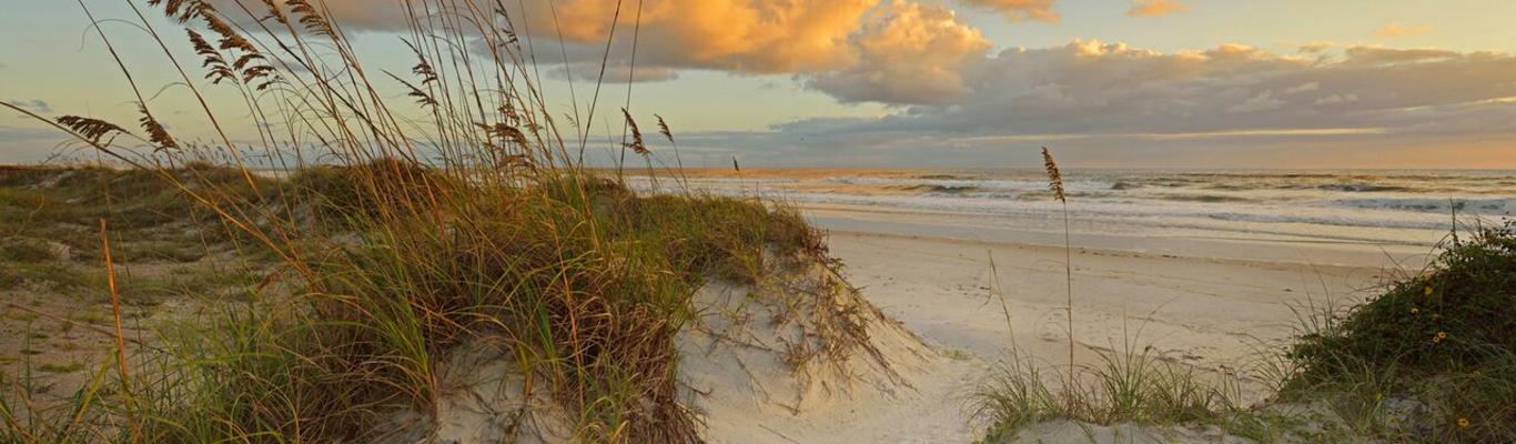 The sun rises over the dunes of Daytona Beach