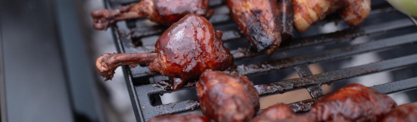 grill filled with meat and corn cobs