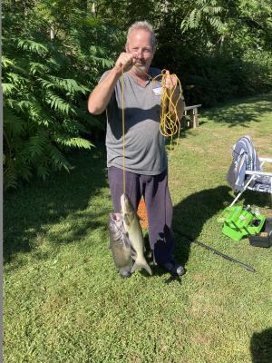 Gary Weimer shows off two catfish that he caught during the fifth annual Forbes Trail Trout Unlimited fishing event for military veterans and first responders.