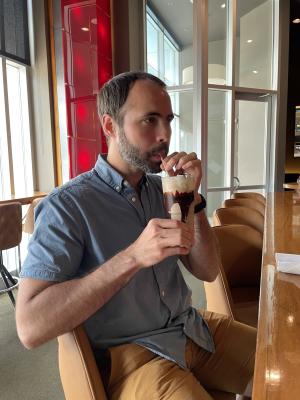A man sips a milkshake at DLUX