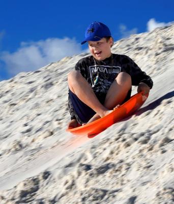 White Sands Boy Blue Hat Sledding