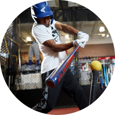Man hitting baseball in batting cage