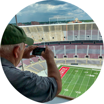 Man taking photo of Ohio Stadium field from the skybox