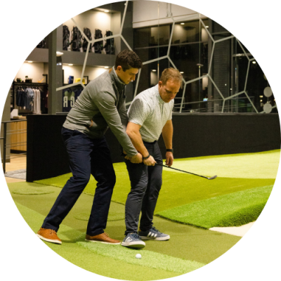 Men practicing golf swing indoors