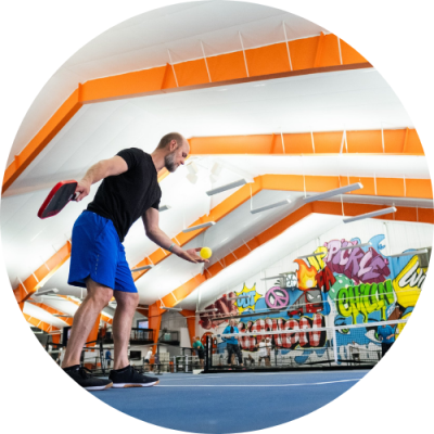 Man serving pickleball on court