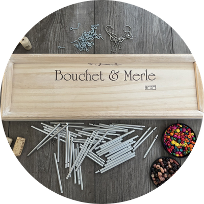 Wooden wine crate, pieces of hardware, and candy sitting on a table