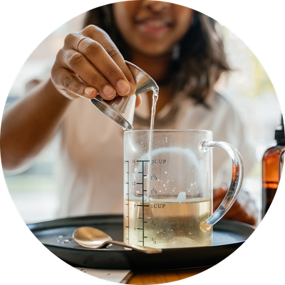 Woman pouring liquid whie making a candle