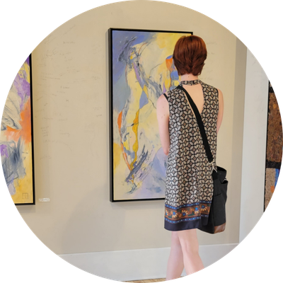 Woman looking at art piece hanging on a wall