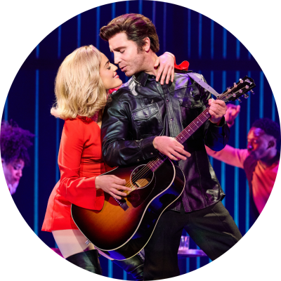 Actor and actress posing with guitar