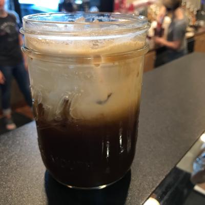 Foamy coffee beverage in mason jar glass
