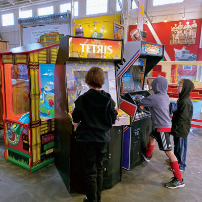 Kids play arcade games at Musee Mechanique