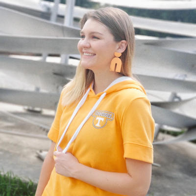 A Tennessee fan wears orange earrings from That Clay Girl