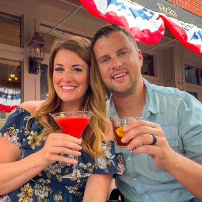 couple toasting with cocktails on a restaurant porch