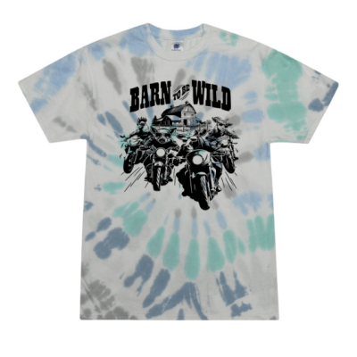 A tie-dye T-shirt in light blue, teal and gray tones featuring a graphic of motorcyclists riding toward the viewer with a barn in the background. Above the image, bold text reads “BARN TO BE WILD.”