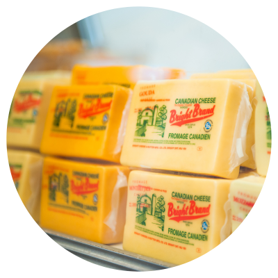 Bricks of Bright Cheddar Cheese in a cooler case