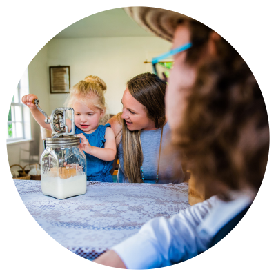 A mother and child churning butter, guided by museum curator
