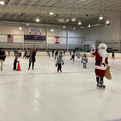 Santa skating on an ice rink with children