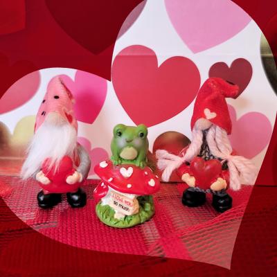 Three Valentine's Day ceramic figures, a frog and two gnomes