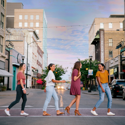 Girls walking on a crosswalk in downtown.