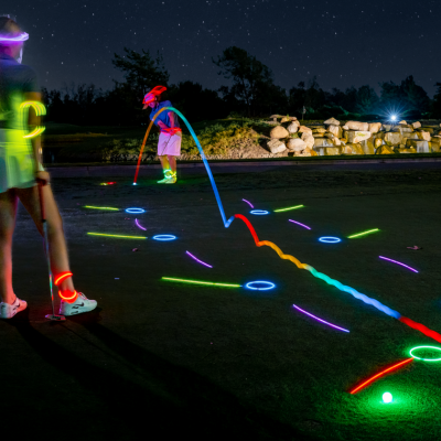 Man and woman playing glow in the dark golf