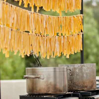 Pasta noodles drying over two metal pots
