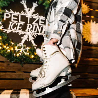close up of someone holding a pair of ice skates
