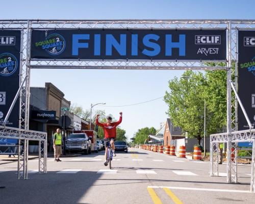 A cyclist crossing a finish line in a race