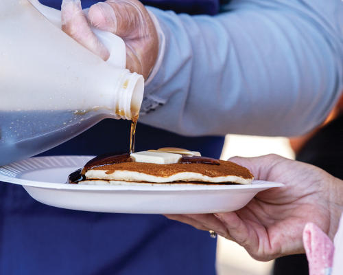 Maple flavored syrup is poured on pancakes at CFD