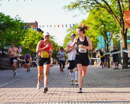 Vermont City Marathon runners high five on Church Street