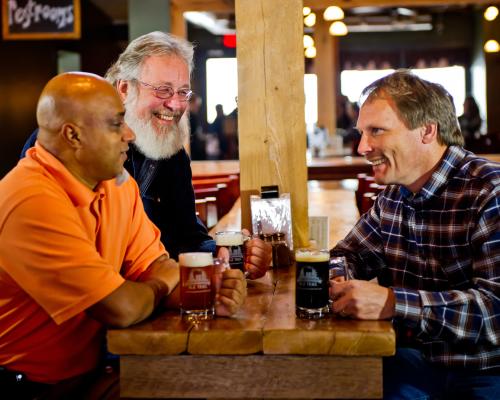 Three men enjoying beers from Mudhook Brewing Company