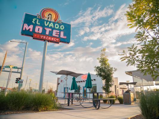 Looking up at the El Vado Motel's neon sign and the site's renovated plaza and office building.