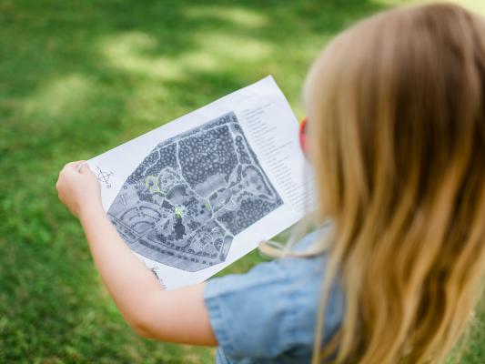 A young girl viewing a map of Fayetteville's Cape Fear Botanical Gardens