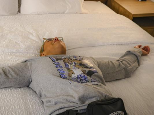 Traveler relaxing on a hotel bed in Fayetteville, North Carolina after visiting friends and family.