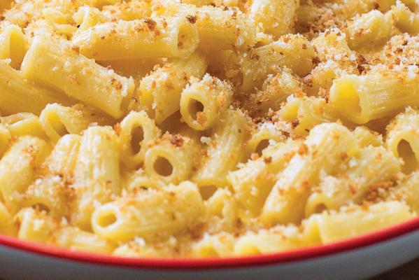 Creamy baked mac n' cheese with bread crumbs placed on a white plate with a red trim