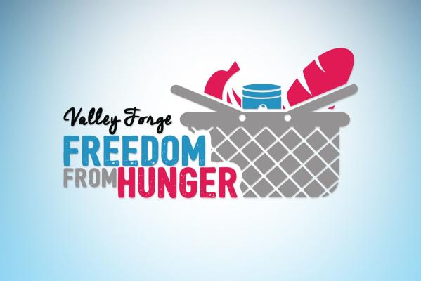 Valley Forge Freedom from Hunger multicolored logo featuring a grocery basket with a canned good and bread. Background color is gradient blue.
