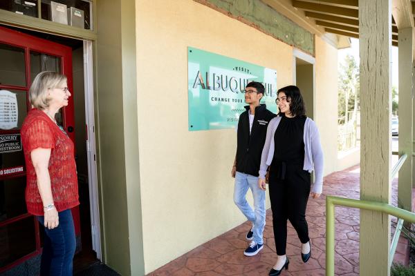 A volunteer greets two visitors at the Old Town Visitor Information Center.