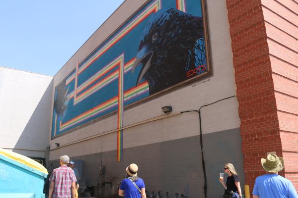 People gaze a mural on a building in Albuquerque
