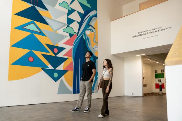 Two people walk through an exhibit at 516 Arts
