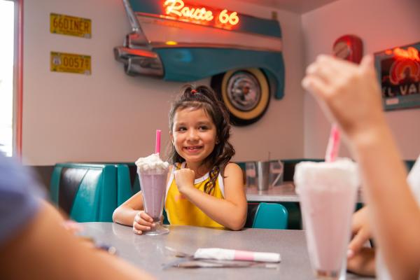 A young girl drinks a shake at Route 66 diner
