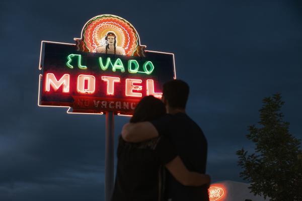 A couple hugs while looking at the El Vado Motel sign.