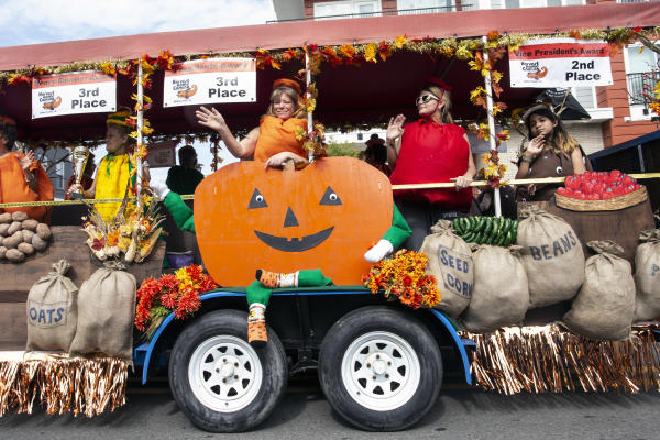 Women and girls dressed as a pumpkin, tomato, corn and potato on a float