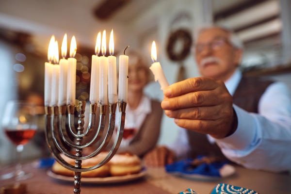 Man lighting menorah candles