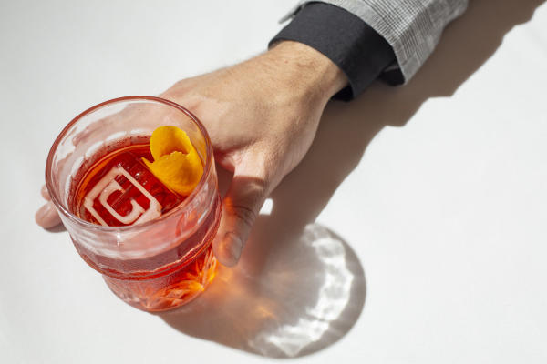 Hand holding Negroni cocktail from Cento