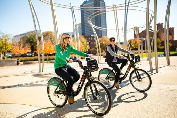 Two women biking with COGO bikes in Columbus